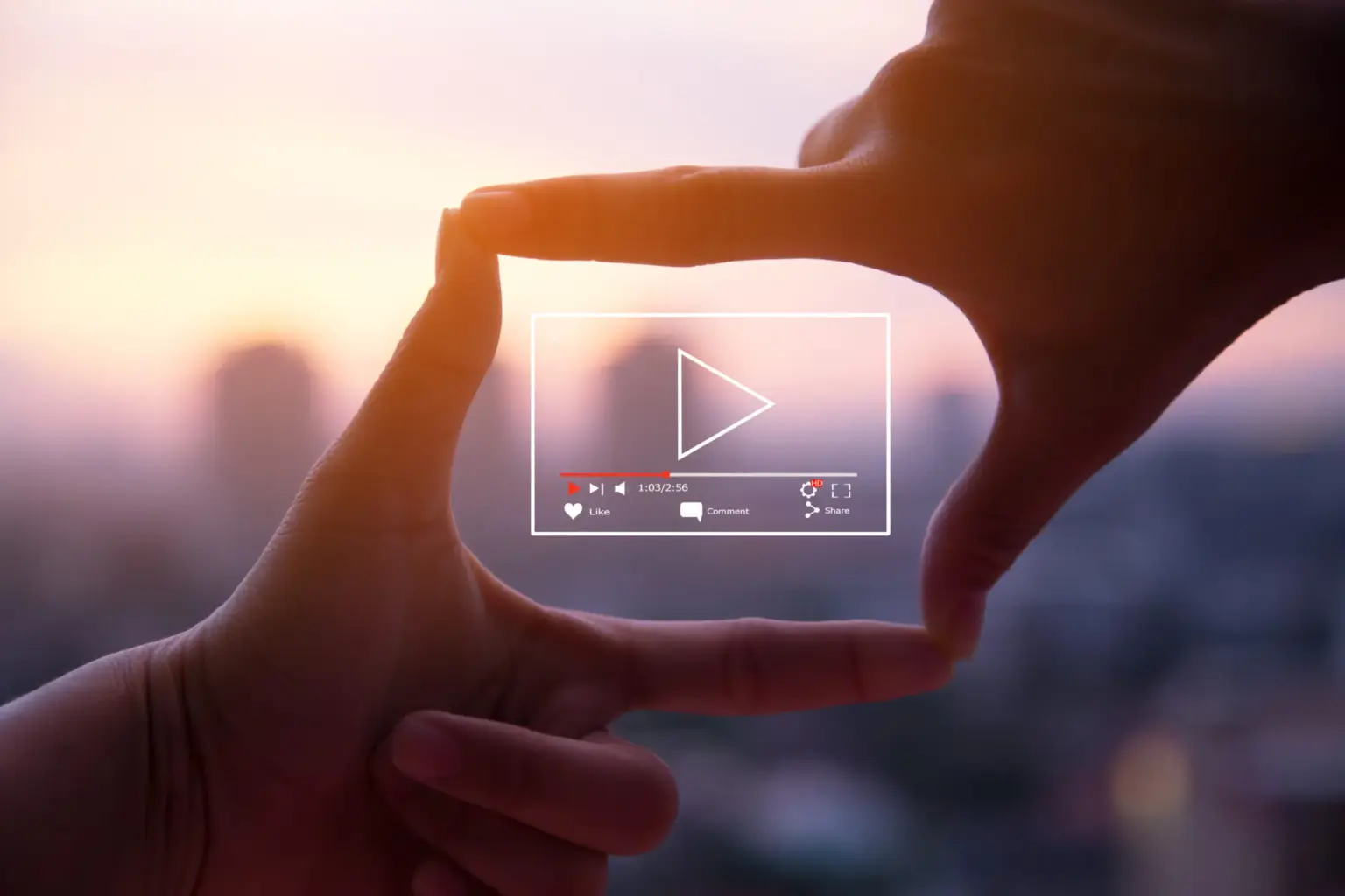 Hände formen ein Rechteck um ein Video-Playback-Symbol vor einem verschwommenen Hintergrund.