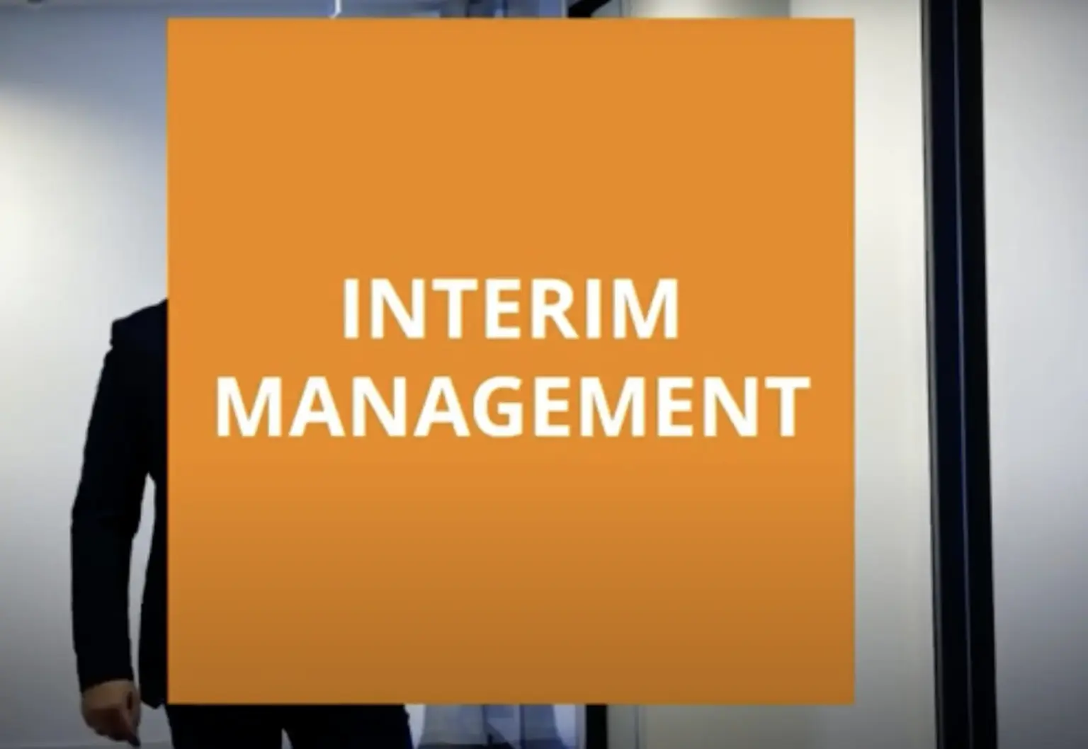 Ein orangefarbener Hintergrund mit dem Text 'INTERIM MANAGEMENT' in weißer Schrift.