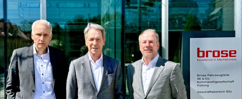 Drei Männer stehen vor dem Brose Gebäude in Coburg, Deutschland.