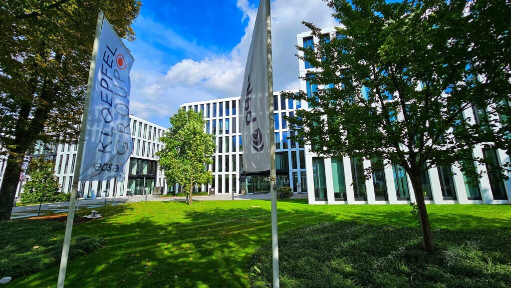 Moderne Bürogebäude der KLOEPFEL Gruppe mit EPSA-Logo und Fahnen im Vordergrund.