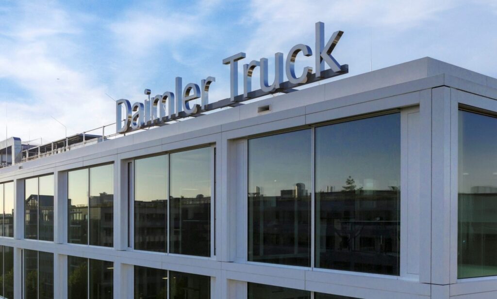 Fassade eines Gebäudes mit dem Schriftzug 'Daimler Truck' auf dem Dach.