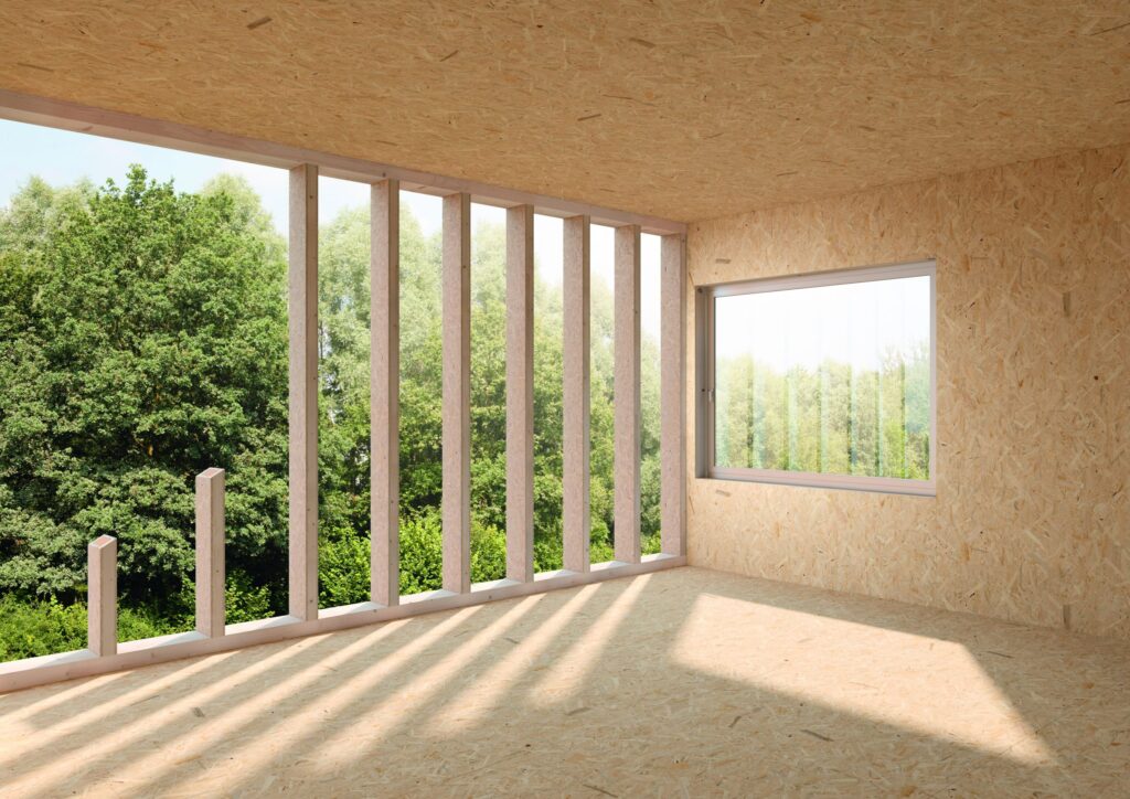 Innenraum mit Holzverkleidung und großen Fenstern, die auf eine grüne Landschaft blicken.