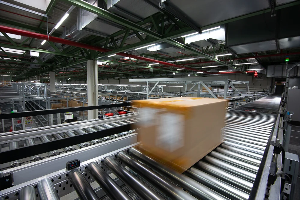 Ein Paket bewegt sich auf einem Förderband in einem Logistikzentrum.