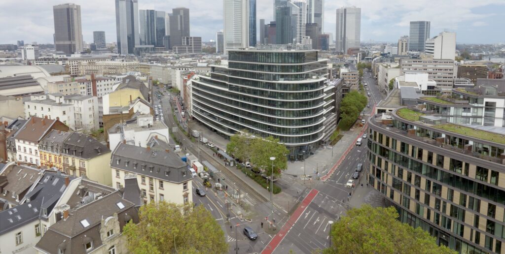 Moderne Architektur der Nestlé Deutschlandzentrale in Frankfurt mit umliegenden Straßen und Gebäuden.