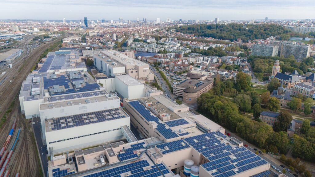 Luftaufnahme eines Industriegebiets mit mehreren Gebäuden und Solaranlagen auf den Dächern.