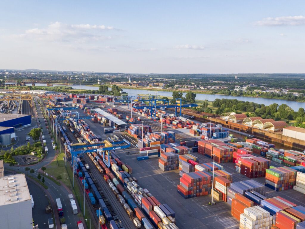 Luftaufnahme eines Containerterminals mit zahlreichen Containern und Transportfahrzeugen.