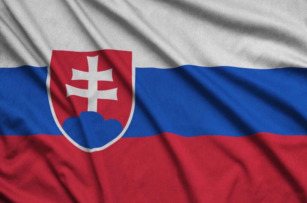 Die Flagge der Slowakei mit einem Wappen auf einem Stoffhintergrund.