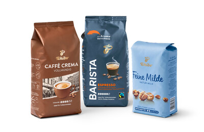 Drei Kaffeepackungen von Tchibo: Caffè Crema, Barista und Feine Milde in verschiedenen Farben.