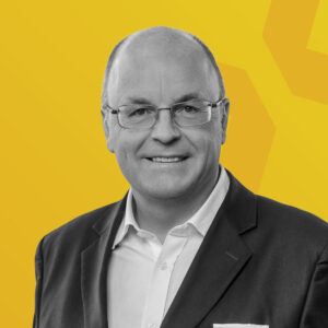 Schwarz-weiß Porträt von Stephan Hofstetter mit gelbem Hintergrund.