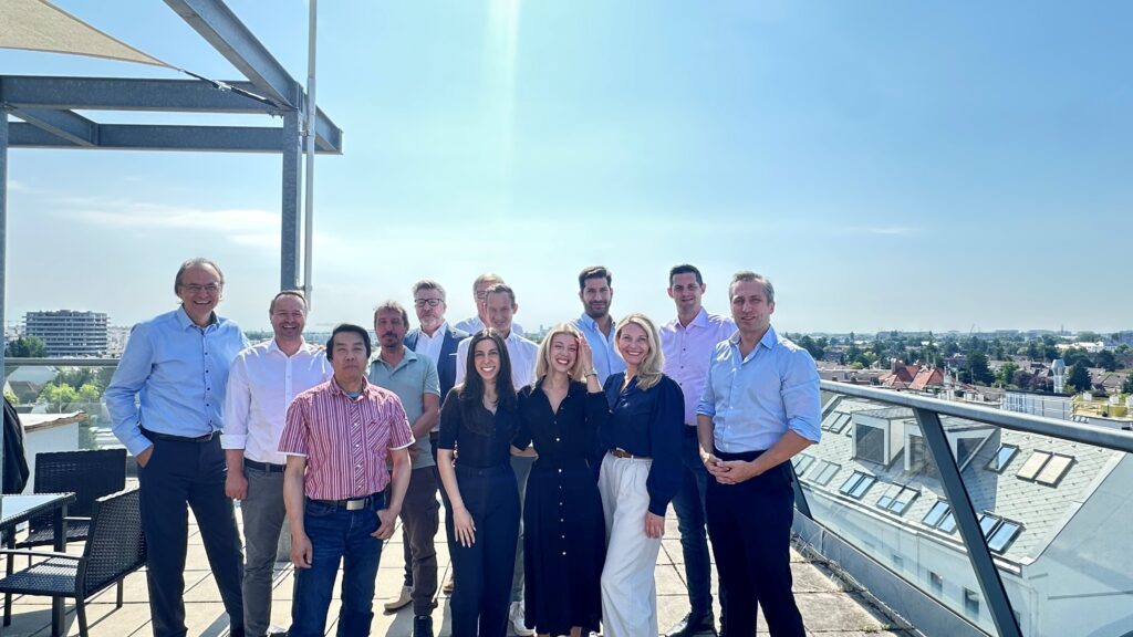 Gruppenfoto des KLOEPFEL-Teams auf einer Dachterrasse in Wien bei sonnigem Wetter.
