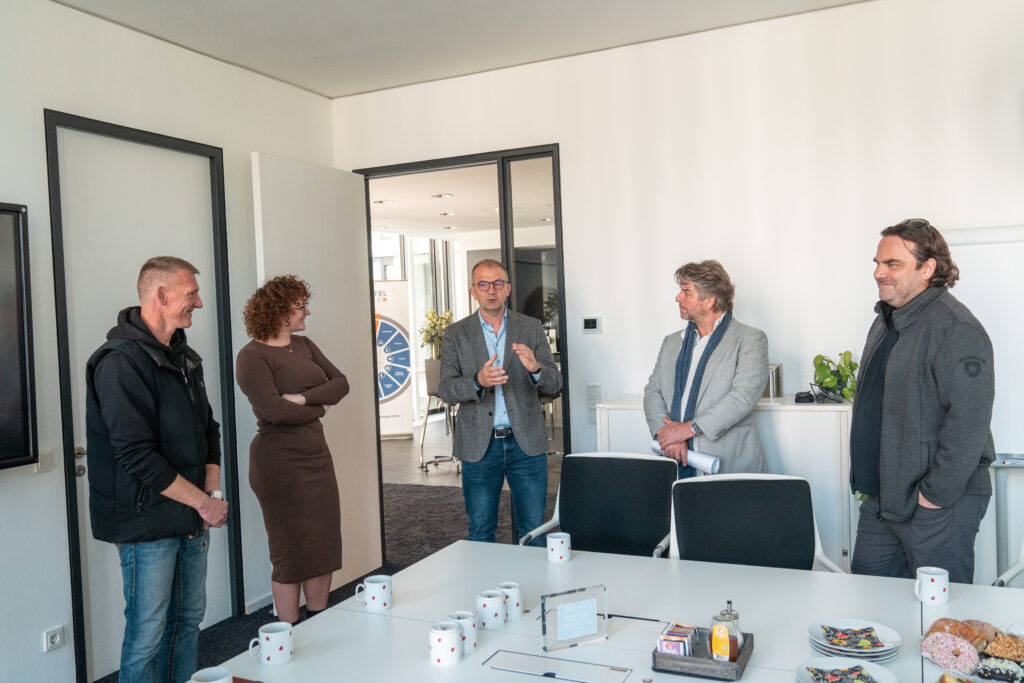 Eine Gruppe von fünf Personen in einem modernen Büro während einer Besprechung.
