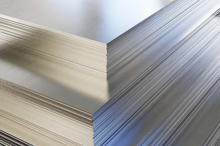 Gestapelte Metallbleche mit glatter Oberfläche in verschiedenen Lichtverhältnissen.