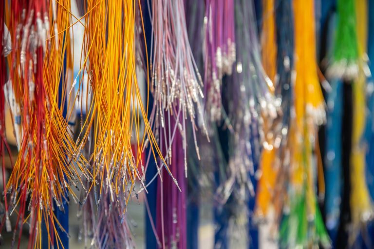 Bunte Kabel in verschiedenen Farben, die an einem Ständer hängen.