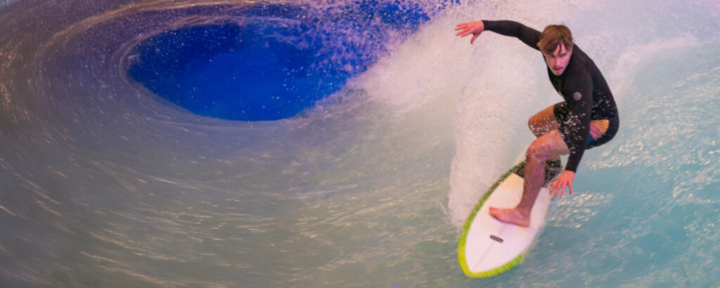 Ein Surfer, der auf einer Welle reitet, während Wasser spritzt.