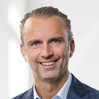 Porträt eines Mannes in Anzug Porträt eines Mannes mit kurzen, hellen Haaren und einem Anzug, der in die Kamera lächelt.