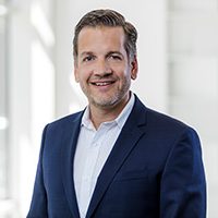 Marc Kloepfel 2023 Porträt von Marc Kloepfel in einem Anzug mit einem neutralen Hintergrund.